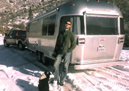 Graham and Flower in front of airstream trailer in snow